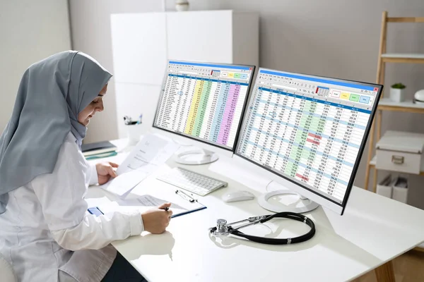 Muslim Woman Working Medical Bill Codes Spreadsheet Data — Stockfoto