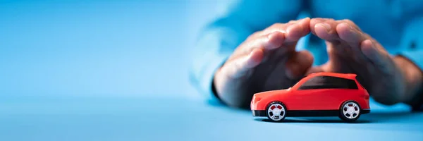 Hand Protecting Red Toy Car Blue Background —  Fotos de Stock