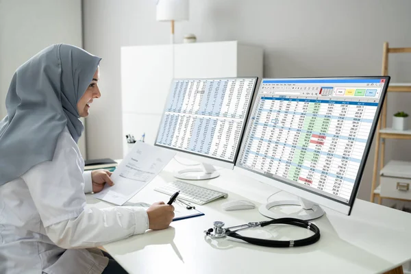 Muslim Woman Working Medical Bill Codes Spreadsheet Data — Stockfoto