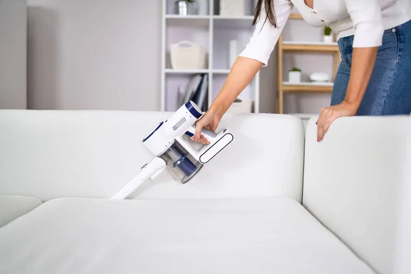 Jonge Vrouwelijke Werknemer Schoonmaken Sofa Met Stofzuiger — Stockfoto