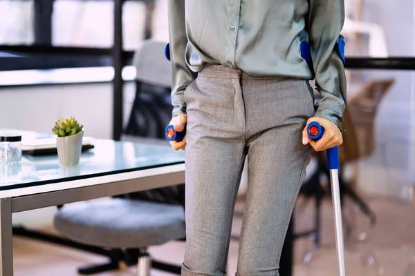 職場で松葉杖をついて歩く障害のあるビジネスマン女性 — ストック写真