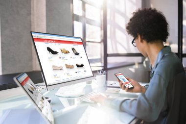 Bilgisayar ve telefondan alışveriş yapan Afrikalı Amerikalı Kadın