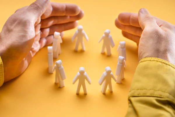 Businesspersons Hand Protecting Person Figures Yellow Background — 스톡 사진