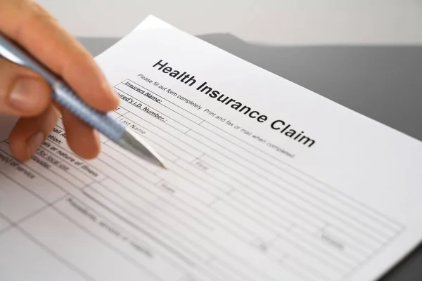 Hand Filling Health Insurance Claim Form Closeup Shot Stock Image