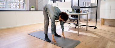 Egzersiz. Ofis masasının yanında duruyor.