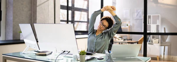 Arms Stretch Exercise Sitting At Desk In Office