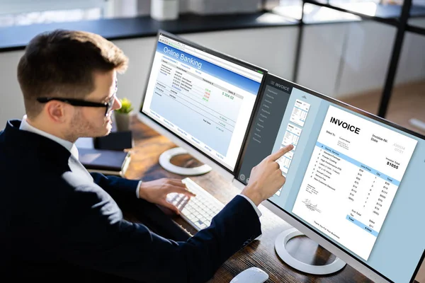 Young Businessman Looking Invoice While Doing Online Banking Computer — Stock Photo, Image