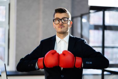 İş adamının ortasında boks eldivenleri ve takım elbisesi var.