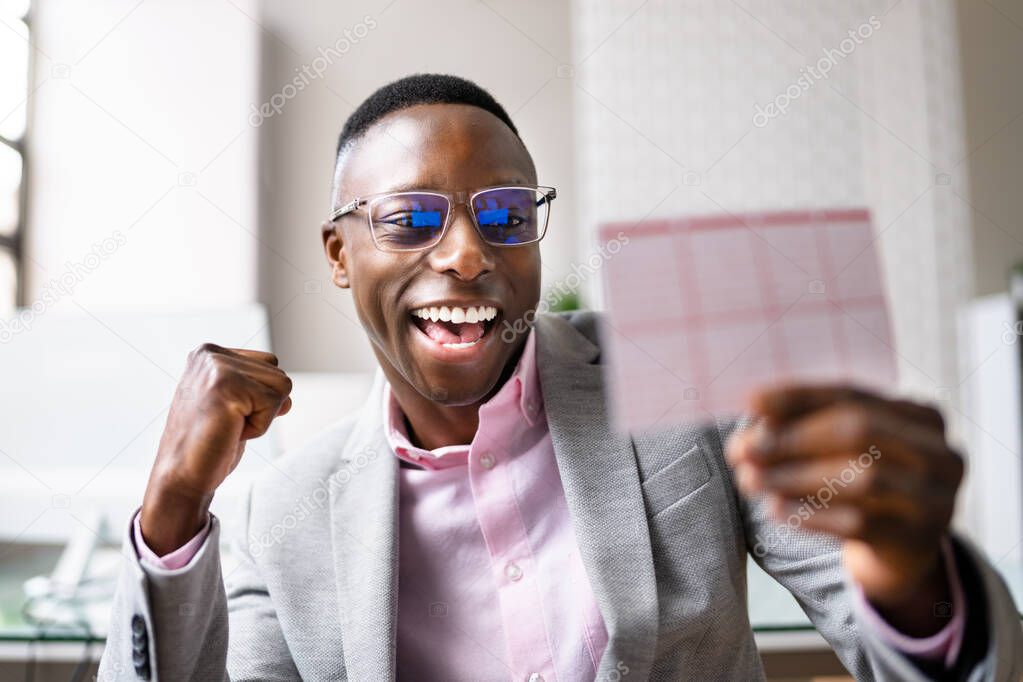 Happy Man Looking At Winning Lottery Ticket