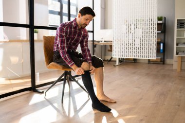 Adam bacaklarına tıbbî baskı çorapları giyiyor.