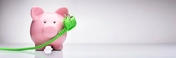 Green Power Plug Pink Piggy Bank Reflecterende Bureau — Stockfoto