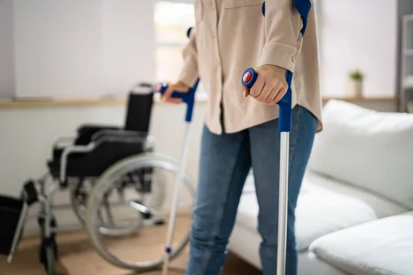Bolało Nogi Przy Użyciu Kul Pobliżu Wózka Inwalidzkiego Domu — Zdjęcie stockowe