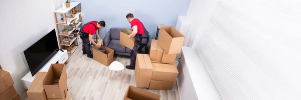 Two Young Movers Uniform Picking Putting Products Cardboard Boxes — Stock Photo, Image