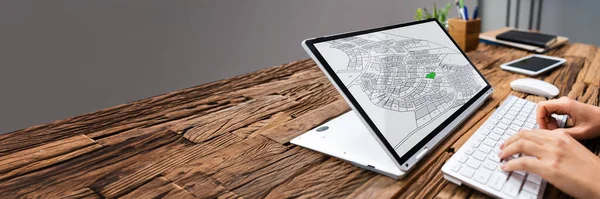 Ofisteki bilgisayardaki kadastro haritasını analiz eden bir iş adamının yakın çekimi.