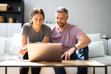 Evde dizüstü bilgisayardan alışveriş yapan mutlu çift.