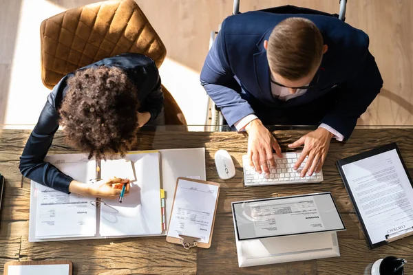 Widok Dwóch Biznesmenów Obliczających Fakturę Biurze Podczas Korzystania Laptopa — Zdjęcie stockowe
