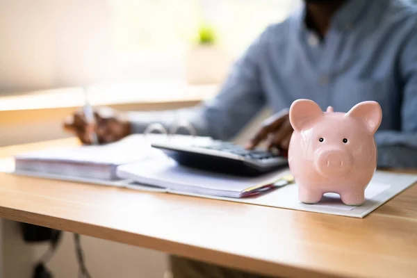 African Accounting Tax Advisor Använda Räknemaskin Och Piggy Bank — Stockfoto