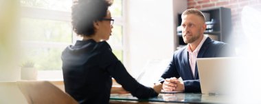 Ofiste birbiriyle konuşan iki iş adamı.