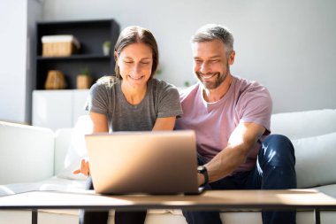 Evde dizüstü bilgisayardan alışveriş yapan mutlu çift.