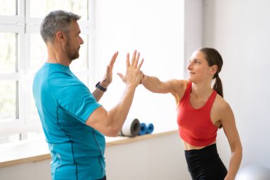 Spor salonunda idman antrenmanı var. Kadın Gücü ve Kendini Savunma