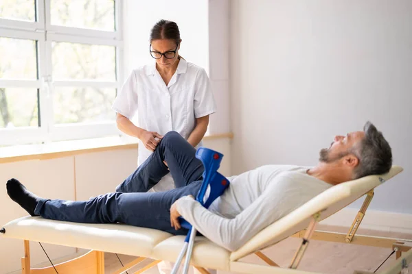 Fysiotherapeut Checkt Man Patiënt Knie Fysiotherapie Pijn — Stockfoto