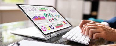 Yakın çekim Işadamı el Bar grafik üzerinde laptop ekran üzerinde beyaz masa üzerinde Işyerinde