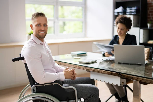 Happy Disabled Businesswoman Working On Laptop In Office