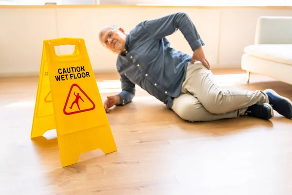 家での注意サインの前に濡れた床に落ちる熟女 — ストック写真