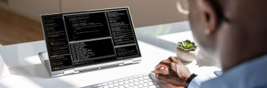 Afrika kökenli Amerikalı programcı masadaki bilgisayarı kullanıyor. Web Geliştirici