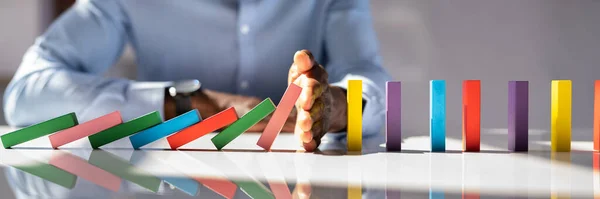 Close Businessman Hand Stopping Colorful Dominoes Falling Office Desk — Stock Photo, Image