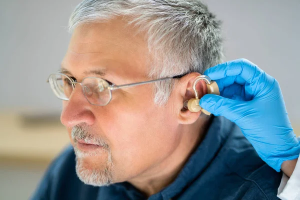 Primer Plano Del Médico Colocando Audífonos Oído Del Paciente Mayor —  Fotos de Stock