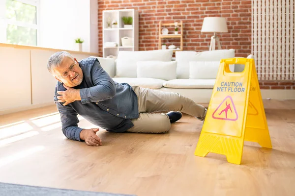 Volwassen Man Vallen Natte Vloer Voorkant Van Waarschuwing Teken Thuis — Stockfoto