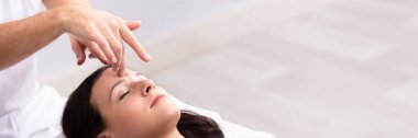 Terapist tarafından Reiki tedavi gören genç bir kadının yakın çekim