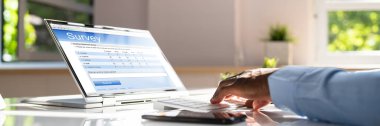 Yakın çekim bir işadamı el laptop Online anket formu doldurma