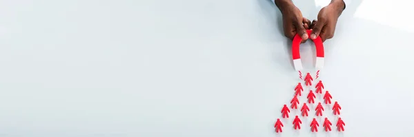 Крупный План Человеческой Руки Привлекающей Красных Людей Подковообразным Магнитом Белом — стоковое фото