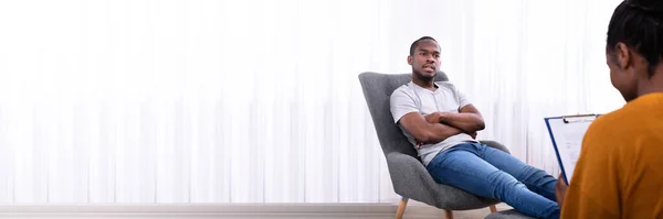 Homem Africano Jovem Sentado Cadeira Perto Psicólogo Feminino Com Área — Fotografia de Stock