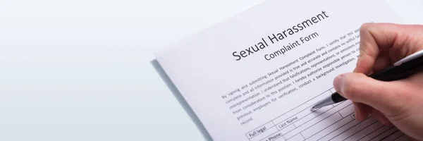 Close Van Een Menselijke Hand Invullen Van Ongewenste Intimiteiten Klachtenformulier — Stockfoto