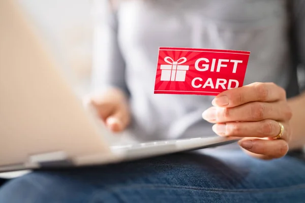 Close Human Hand Holding Gift Card While Using Laptop — Stock Photo, Image