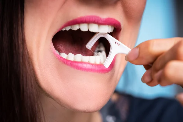 デンタルフロスで歯のクリーニング女性の手のクローズ アップ — ストック写真
