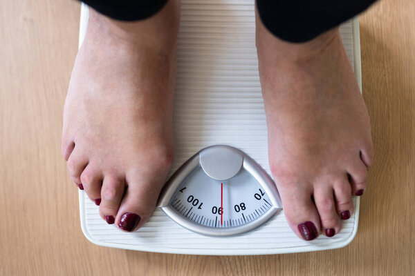 Low Section Of A Person Standing On Weighing Scale