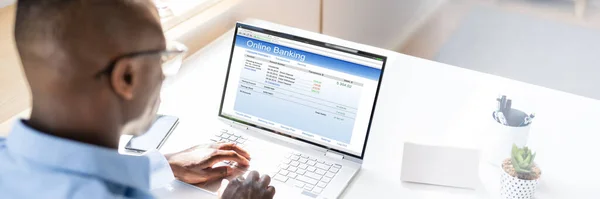ホワイトデスク上のノートパソコンでオンラインバンキングを行うビジネスマンの手のクローズアップ — ストック写真