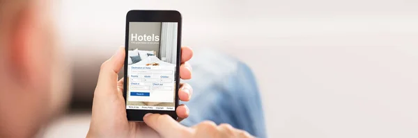 低価格ホテルのオンラインを使用してスマート フォンを持っている人のクローズ アップ アプリケーション — ストック写真