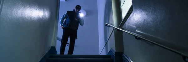 Erkek Güvenlik Görevlisi Feneriyle Merdivenlerde Arama Yapıyor — Stok fotoğraf