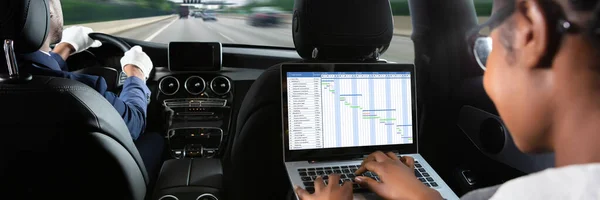 Afrikanische Geschäftsfrau Untersucht Gantt Diagramm Auf Laptop Bei Autofahrt — Stockfoto