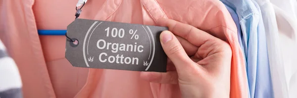 Close Woman Hand Holding Label Showing 100 Percent Organic Cotton — Stock Photo, Image