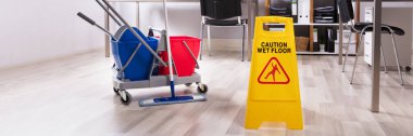 Wet Floor Caution Sign And Cleaning Equipment On Floor