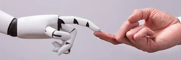 Робот Трогает Человеческий Палец Сером Фоне — стоковое фото