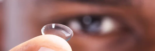 Close-up Of A Man Holding Transparent Contact Lens In His Finger