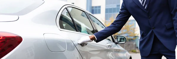 Diener Öffnet Graue Autotür Auf Der Straße — Stockfoto