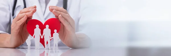 Close Mão Médico Protegendo Família Cortada Com Forma Coração Vermelho — Fotografia de Stock